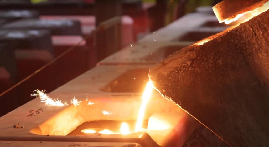 Molten metal being poured into a mold in a foundry.